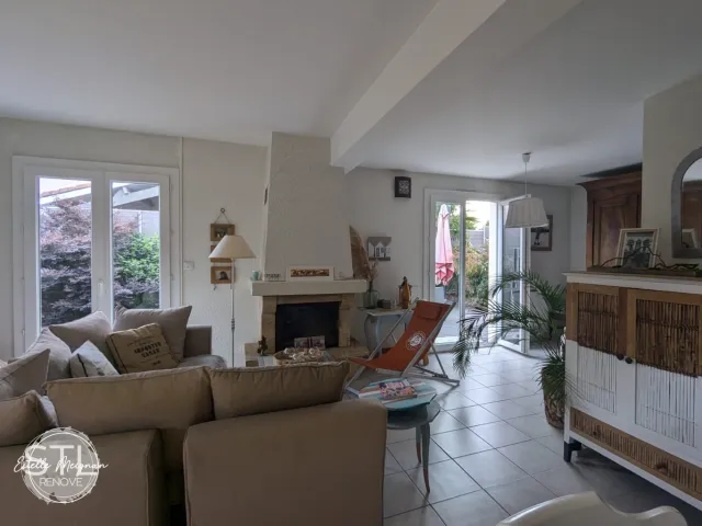 Salon existant avant intervention d'une décoratrice d'intérieur, avec canapé taupe et cheminée, illustrant le point de départ d'un projet STLrenove.